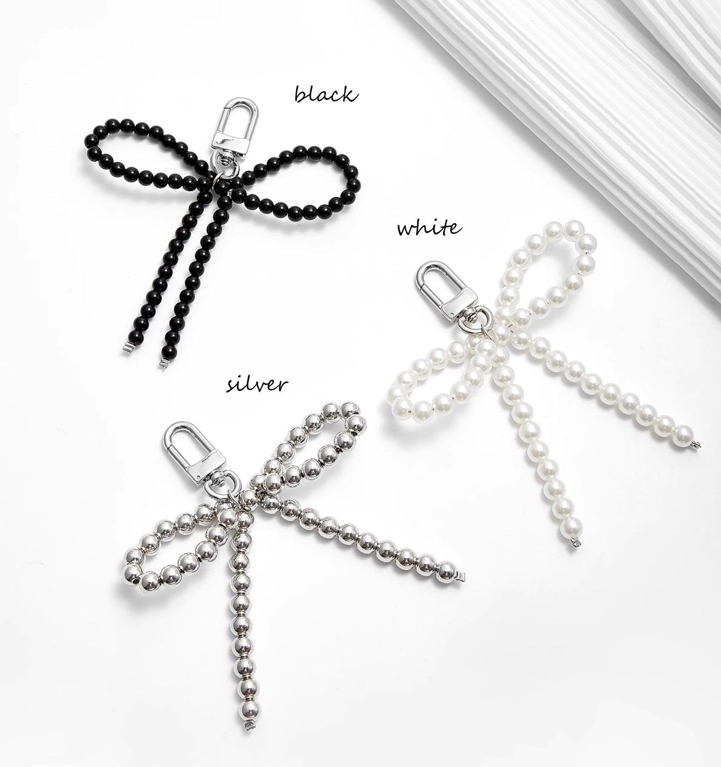 Arcadie matelassé nappa leather bag charm, pearl decorative accessory, bow-shaped keychain.