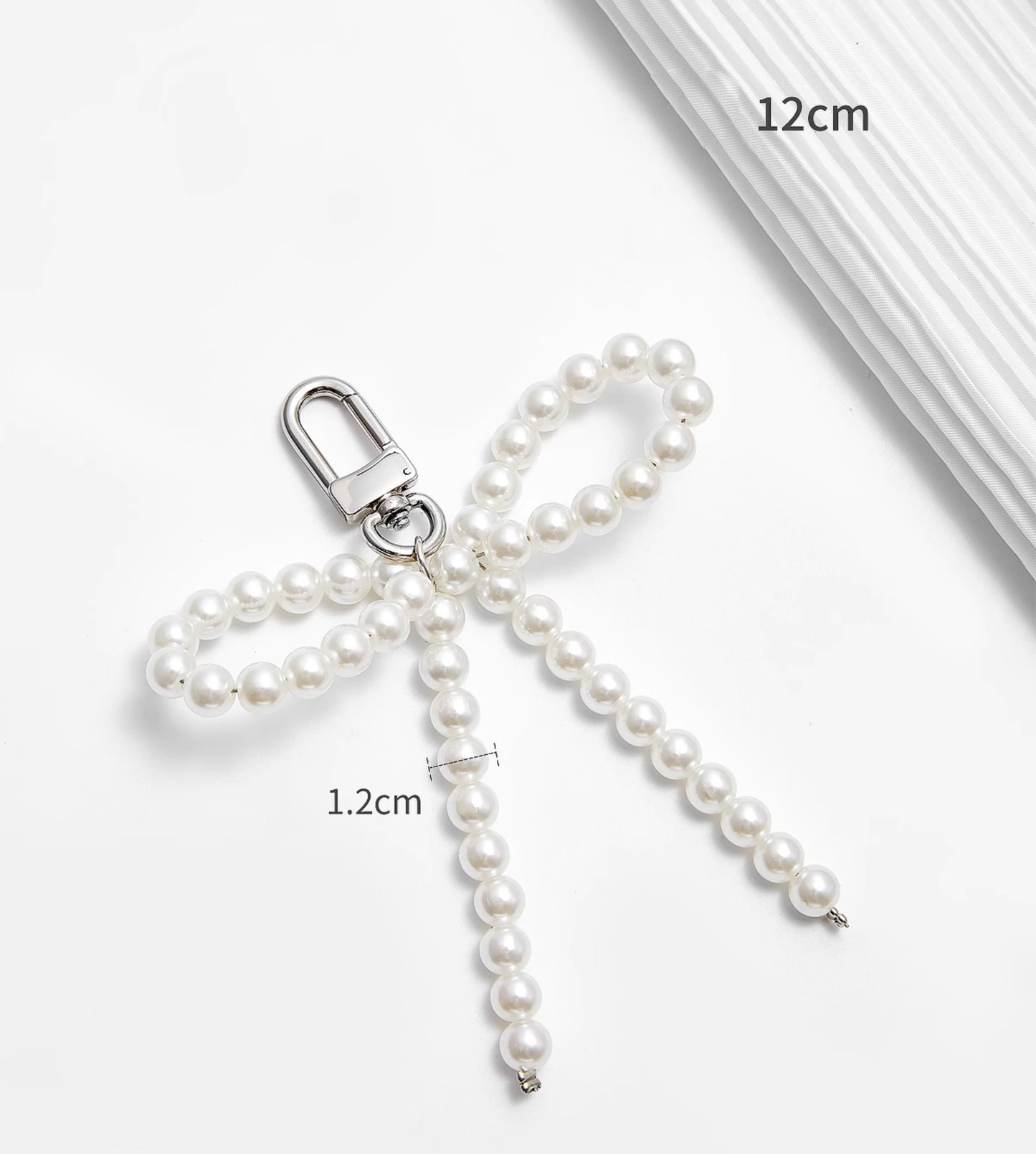 Arcadie matelassé nappa leather bag charm, pearl decorative accessory, bow-shaped keychain.